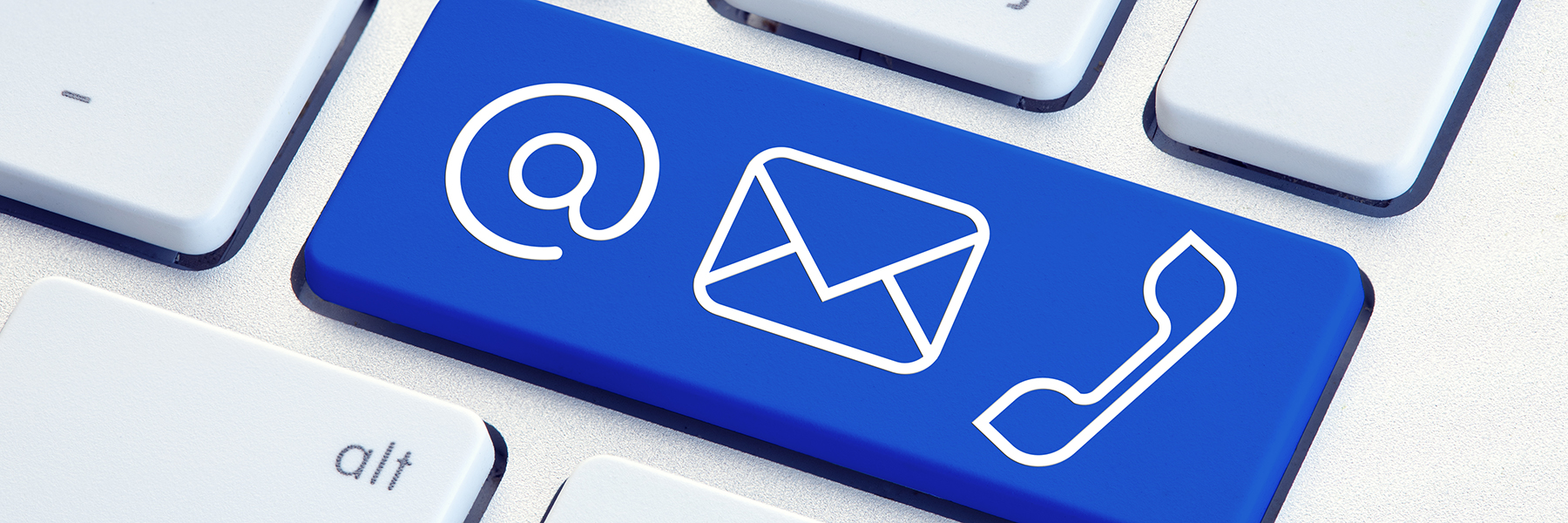 A computer keyboard with a large blue button with email, mail, and phone icons.